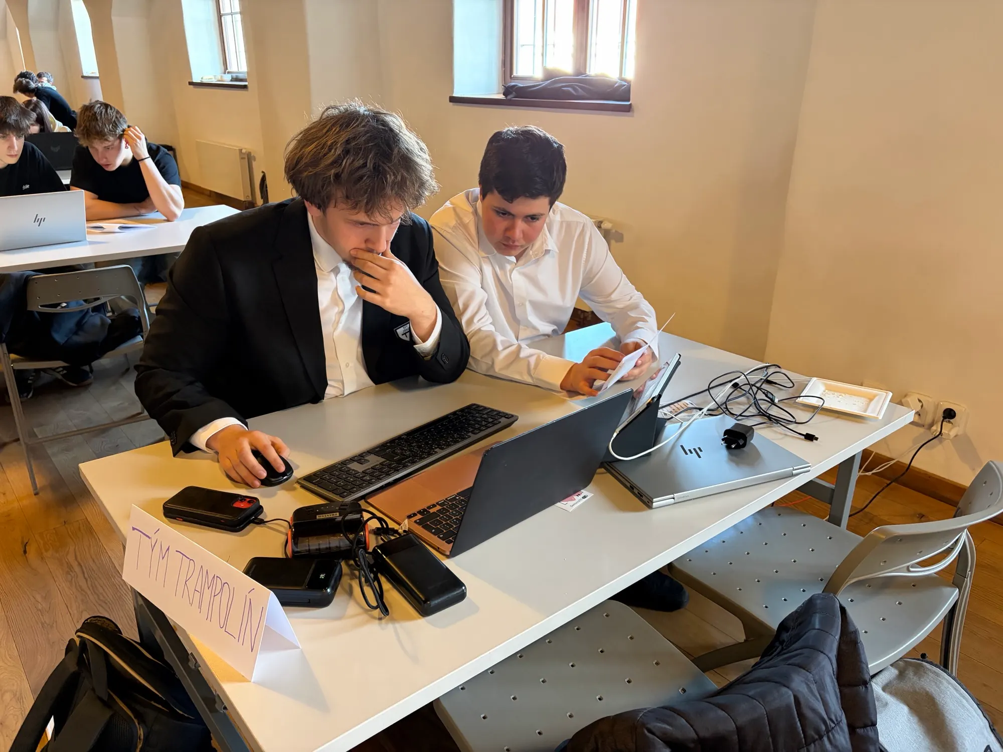 Two students discussing work at a laptop